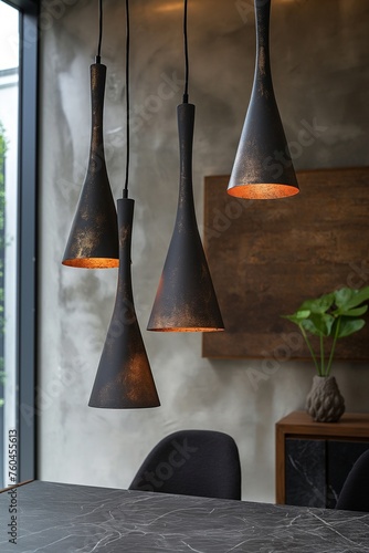 Sleek, dark tapered pendant lights with orange-glow interiors in a modern room with concrete wall