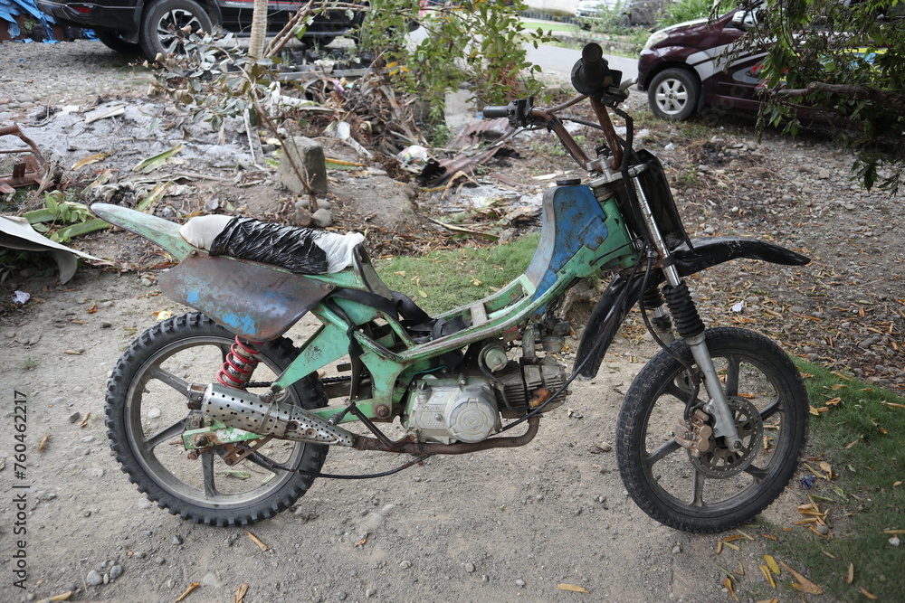 an old rusty motorbike used for farming by people in rural Asia