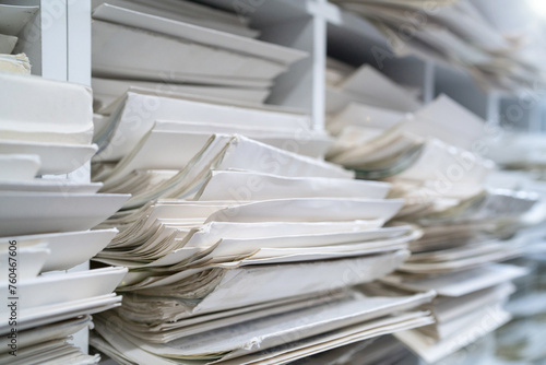 A stack of documents is piled up on the bookshelf.