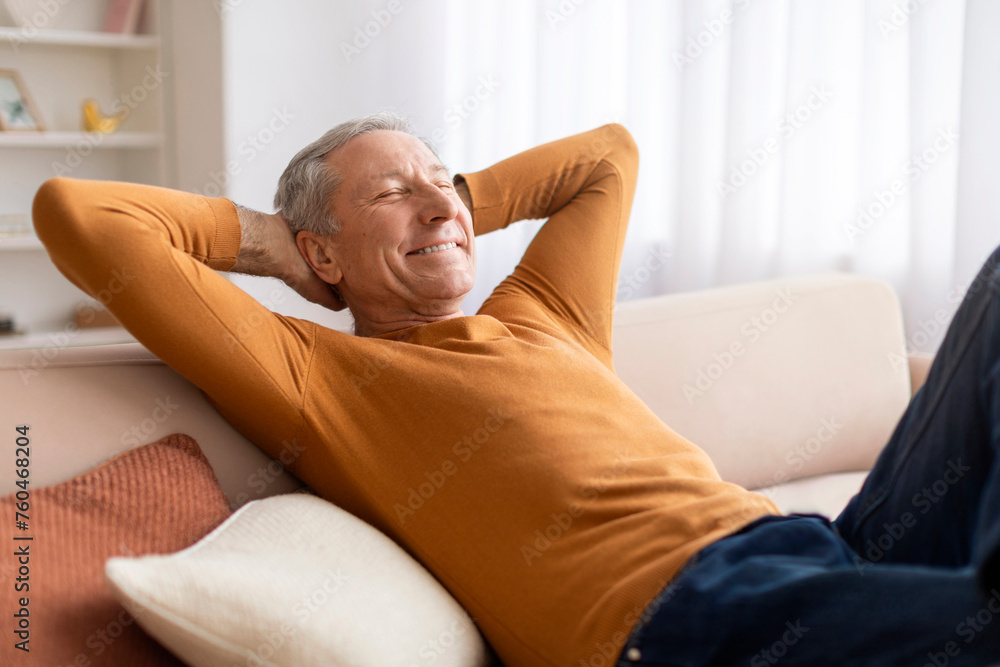 Relaxed elderly man reclining on couch at home Relaxed elderly man reclining on couch at home