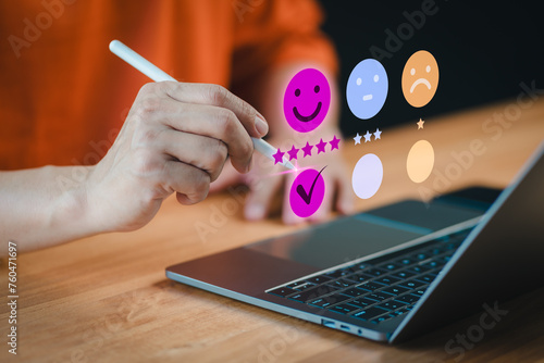 On a laptop, a customer selects a happy smile face icon on a virtual screen, signaling satisfaction in service. Concept of assessment, testimonial, customer service feedback, and opinion rating.