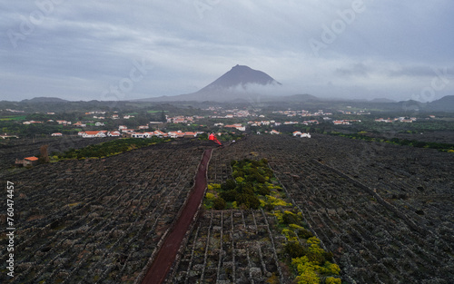 Foto Traditional red windmill surrounded by volcanic stone vineyards on Pico Island in the Azores, Portugal