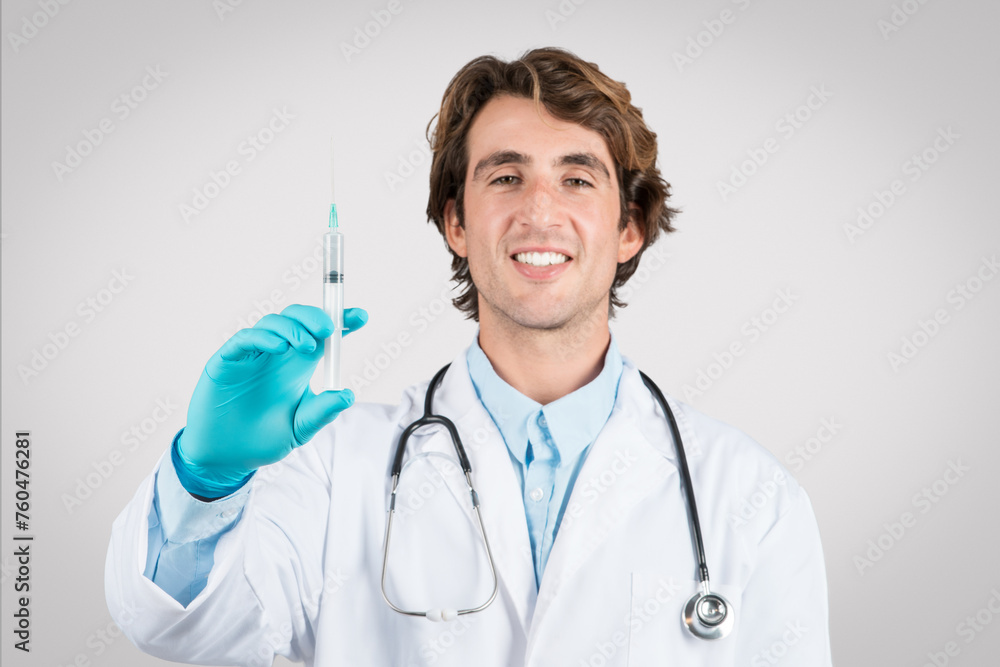Happy male doctor holding syringe, ready to vaccinate Happy male doctor holding syringe, ready to vaccinate