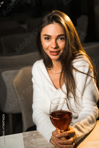 Young woman holding a glass of wine.Woman drinking wine in a restaurant.Red wine concept