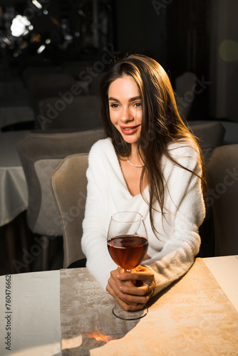 Young woman holding a glass of wine.Woman drinking wine in a restaurant.Red wine concept