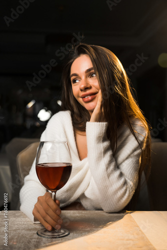 Young woman holding a glass of wine.Woman drinking wine in a restaurant.Red wine concept