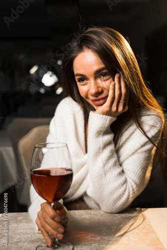Young woman holding a glass of wine.Woman drinking wine in a restaurant.Red wine concept
