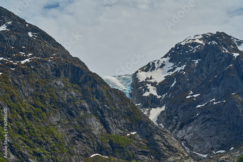 Blue Bondhusbreen Glacier hanging in the mountains over the Bondhusvatnet Lake and in Sundal, Vestland, Norway photo