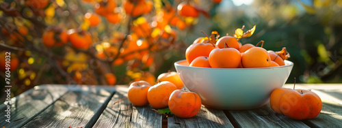 a white bowl of persimmons on a nature background photo