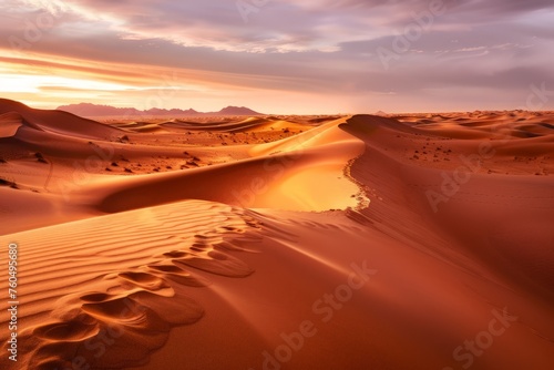 A vast desert terrain featuring towering sand dunes in the foreground with majestic mountains looming in the background