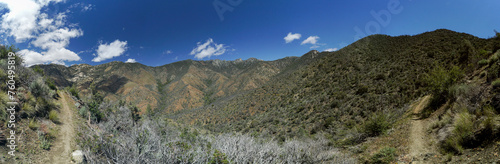 A panoramic view of a mountain range with a clear blue sky