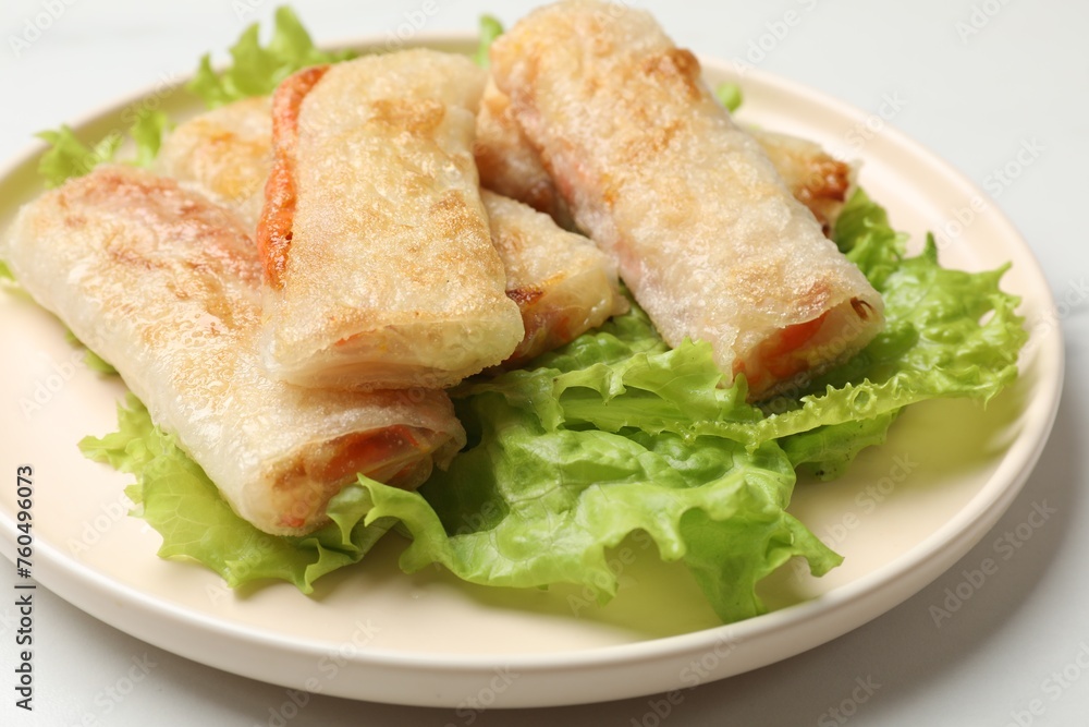 Delicious fried spring rolls on white table, closeup