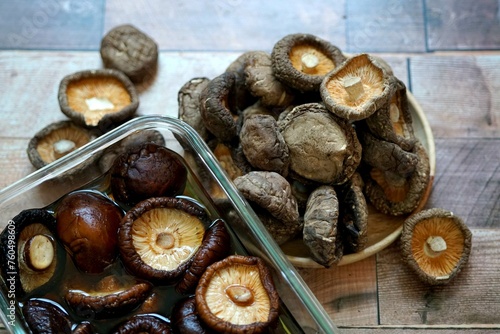 The Dried shiitake mushrooms on a wooden background.