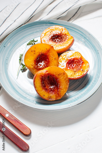 Baked peaches with honey and cinnamon in a ceramic plate. summer dessert