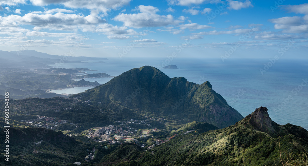 Fototapeta premium Overlooks two peaks in northeast Taiwan, teapot mountain and Keelung mountain, and Keelung island also in the distances of ocean, sunlight shines on the village, in Jiufen, Jinguashi, New Taipei
