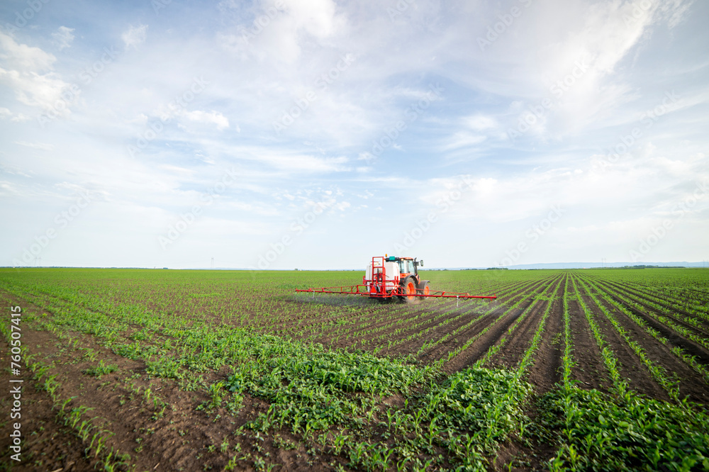 Tractor spraying pesticides at corn fields Tractor spraying pesticides at corn fields