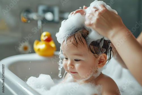 Mother is washing the kid's hair in the tub
