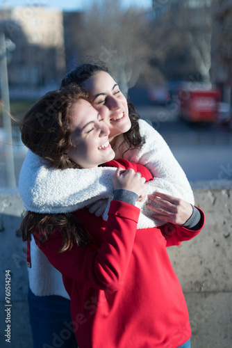 Joyful hug between two friends outdoors