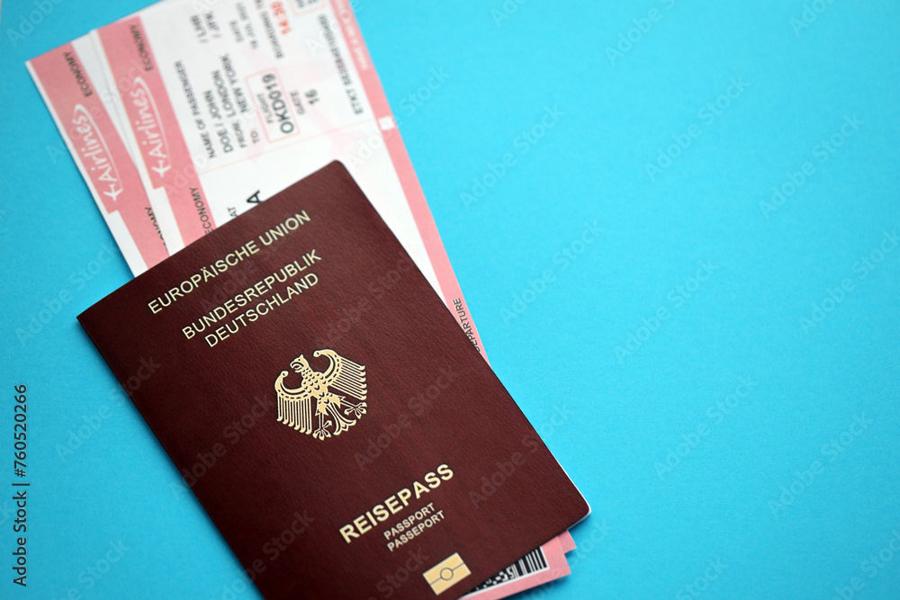 Red German passport of European Union with airline tickets on blue background close up. Tourism and travel concept Red German passport of European Union with airline tickets on blue background close up. Tourism and travel concept