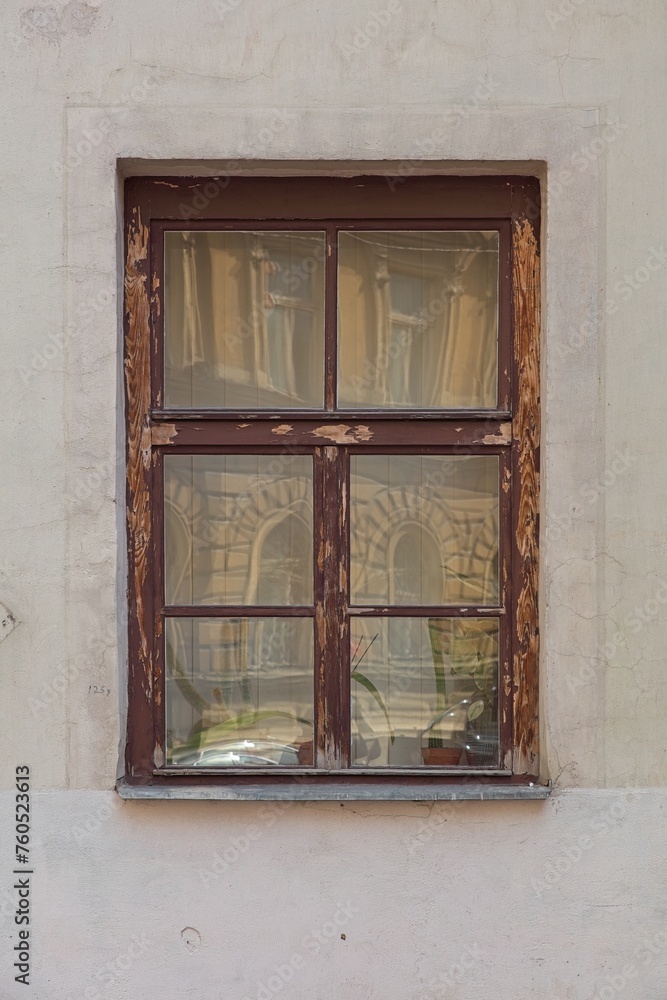 Closeup of old weatherd brown wood frame window on stone building.