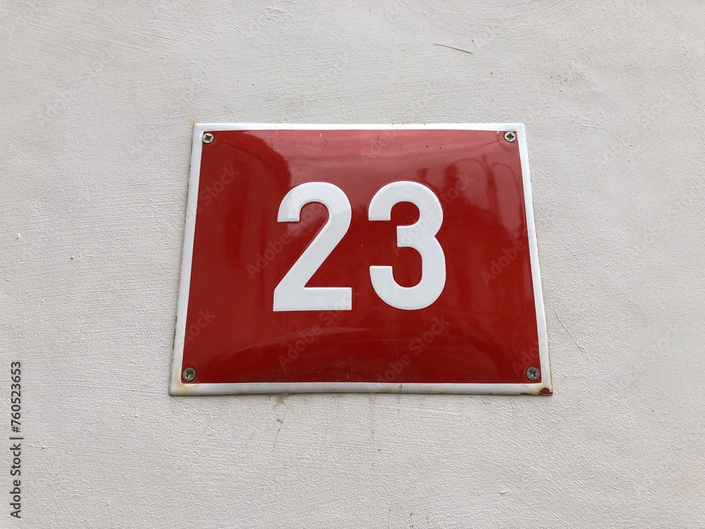 Red metal numberplate that says 23 Red metal numberplate that says 23