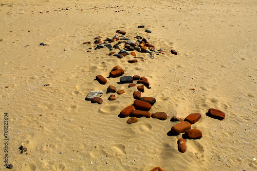 Pebbles, rocks and stones in the sand at the beach photo