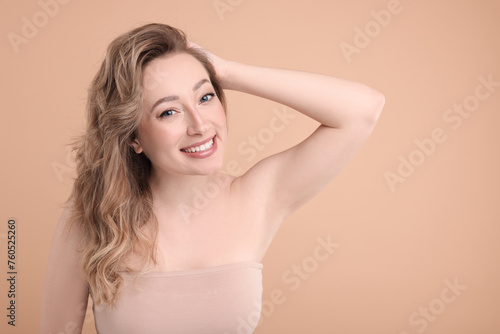 Portrait of smiling woman on beige background. Space for text