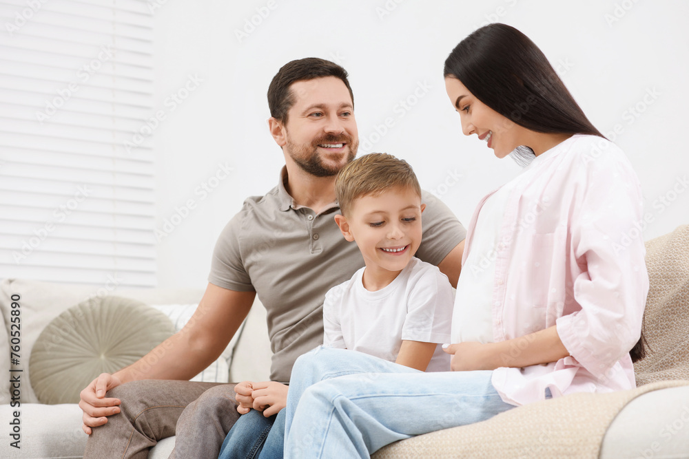 Happy pregnant woman spending time with her son and husband at home Happy pregnant woman spending time with her son and husband at home