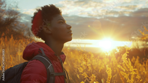 Side portrait of a black female teenager against the background of the sky and mountains, sunset atmosphere, lifestyle concepts, and activities.