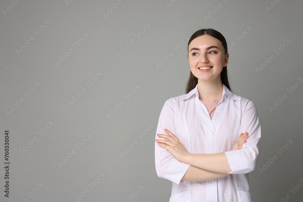 Cosmetologist in medical uniform on grey background, space for text Cosmetologist in medical uniform on grey background, space for text