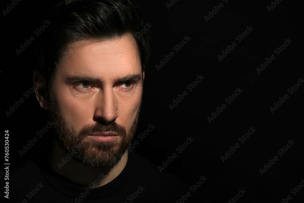 Evil eye. Man with scary eyes in darkness, space for text Evil eye. Man with scary eyes in darkness, space for text
