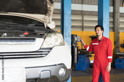 Male mechanic working at garage. Professional Asian male mechanics checks, repair and maintenance tires car at auto car repair service. Car service and Maintenance concept © amorn