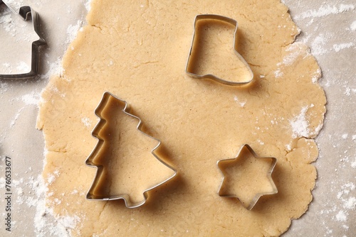 Making Christmas cookies. Raw dough and metal cutters on parchment paper, flat lay