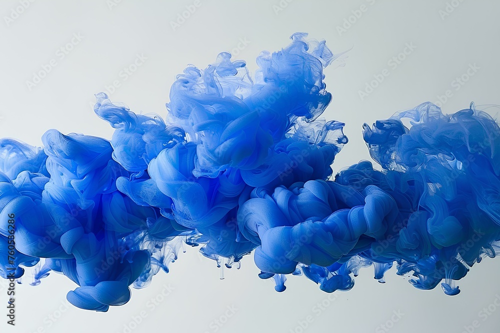 A blue substance is floating in the air with a white background and a white background behind it is A blue substance is floating in the air with a white background and a white background behind it is