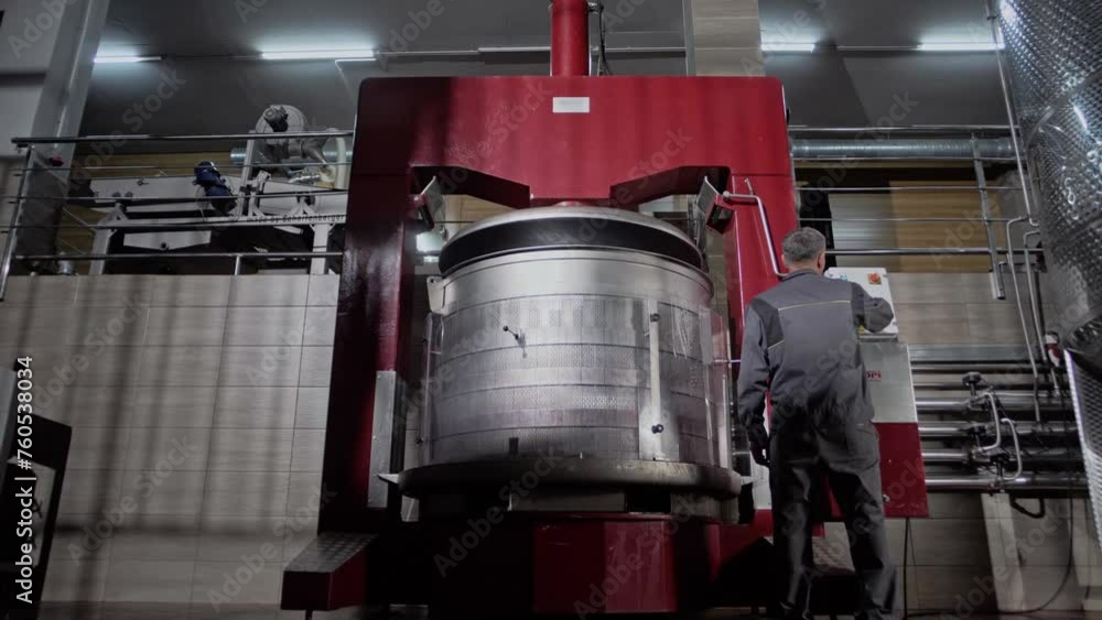 Huge red basket hydraulic press for squeezing juice from grapes to make wine in a winery. Huge red basket hydraulic press for squeezing juice from grapes to make wine in a winery.