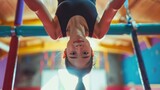 asian female gymnast hanging upside down on the uneven bars in a bright gym
