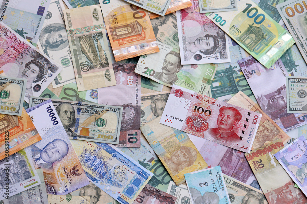 Many banknotes of different currency. Background of big amount of random money bills close up