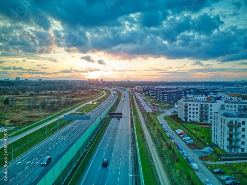 Aerial view of the expressway and fast-driving cars during a dramatic sunset.