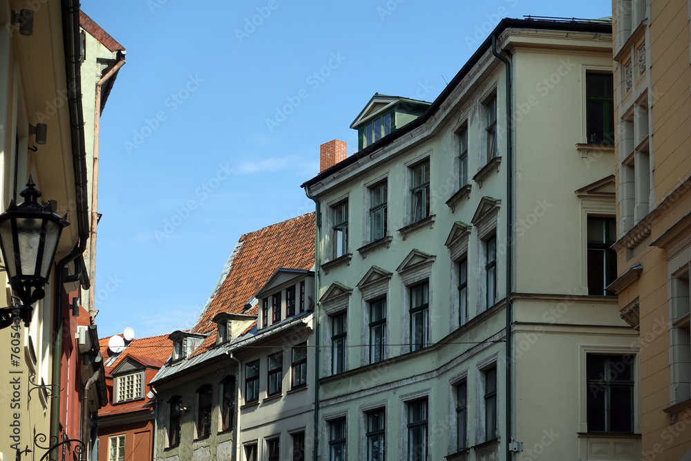 Top floors of beautiful vintage colorful houses on Jauniela street in Riga old town in sunny cloudless day