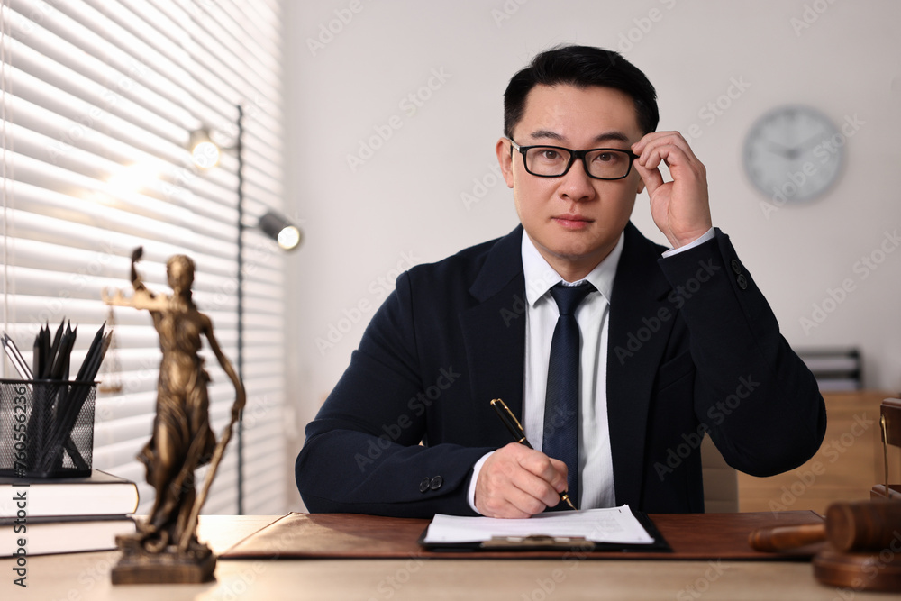 Notary writing notes at wooden table in office Notary writing notes at wooden table in office