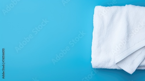 White cotton towels on a blue background. Bathroom decor and accessories.