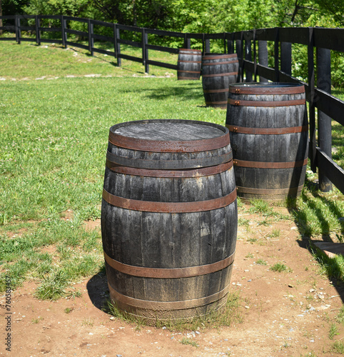 Used bourbon barrels along a fence line