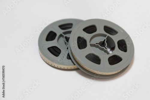 Two reels of old 8mm film stacked on each other against a white background.  photo