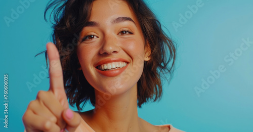 A woman smiling and making a peace sign gesture. Suitable for various concepts and designs photo