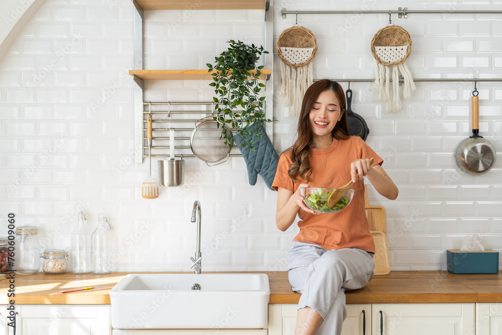 Portrait of beauty body slim healthy asian woman eating vegan food healthy with fresh vegetable salad in kitchen at home.diet, vegetarian, fruit, wellness, health, green food.Fitness and healthy food - obrazy, fototapety, plakaty 