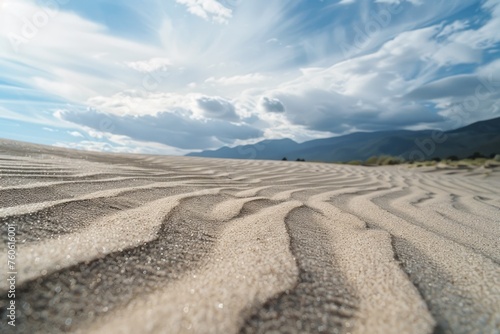 Sand dunes with distant mountains and cloudy sky. Suitable for travel brochures