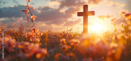 A cross standing in a vibrant field of flowers. Suitable for religious themes or nature concepts photo