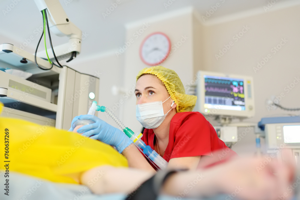 Female anesthesiologist injects anesthesia into patient face mask ...