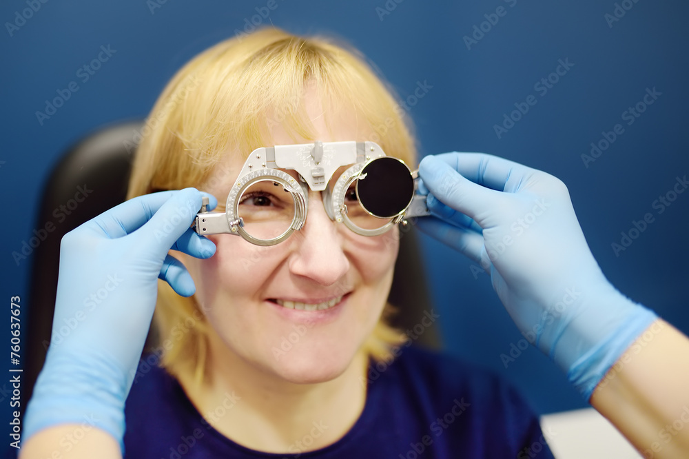 Smiling senior woman wearing optometrist trial frame at ophthalmology clinic. Appointment by ophthalmologist or visit in opticians shop for selected contact lenses and glasses. Vision checkup Smiling senior woman wearing optometrist trial frame at ophthalmology clinic. Appointment by ophthalmologist or visit in opticians shop for selected contact lenses and glasses. Vision checkup