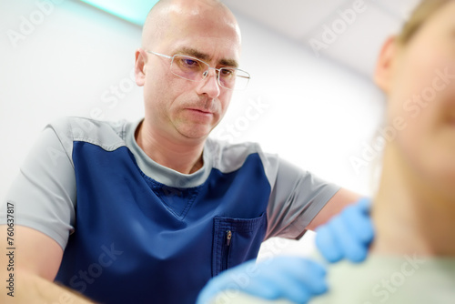 Woman at a neurologist s appointment talks about pain symptoms in the neck  shoulders  and back. An orthopedic surgeon examines the patient.Consultation of a specialist in the rehabilitation of a pati